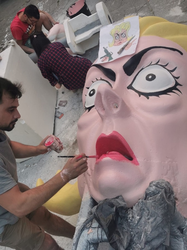 Artists painting a large colorful sculpture for the Borat production